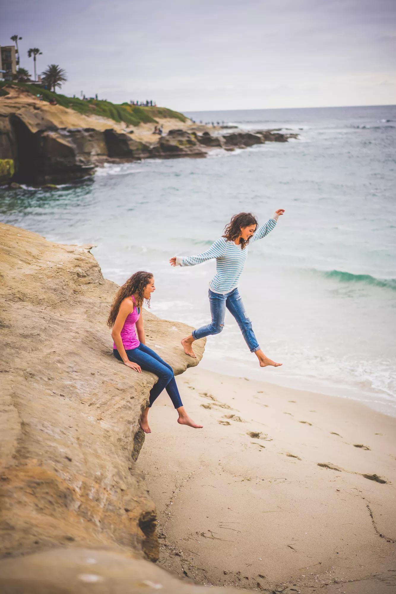 Girls jumping off rocks in La Jolla, San Diego, California.